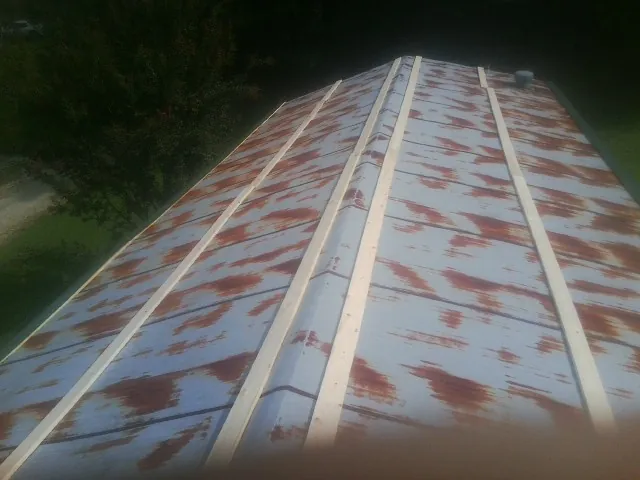 Rusted metal roof panels with new wood purlins before replacement — Storm Damage Roof Repair in Walters by Roofing Brothers