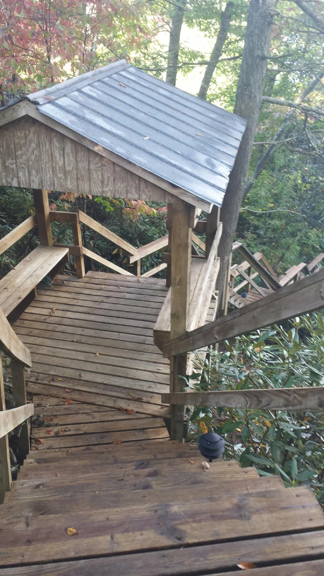 Metal roofed shelter over wooden steps on a wooded walkway — Skylight Repair & Installation work by our crew in Walters
