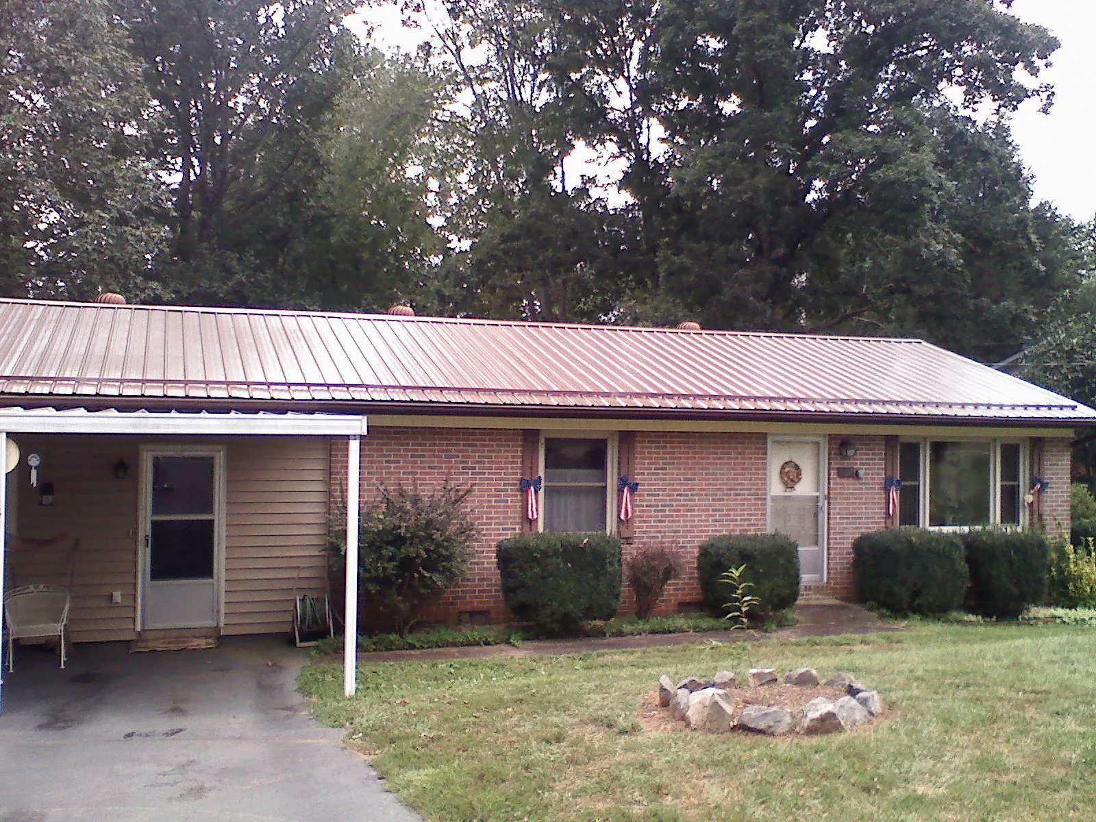 Bronze metal roof and carport on a brick ranch home — Roof Repair work by our crew in Walters
