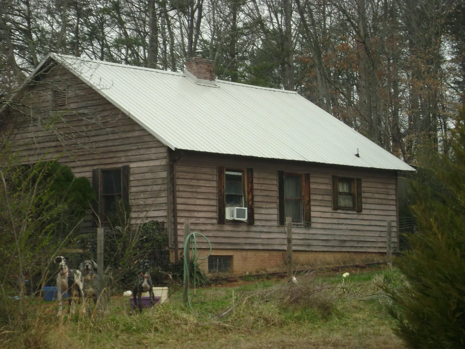 White metal roof on an old wood sided farmhouse, from a Metal Roof Installation job in Walters